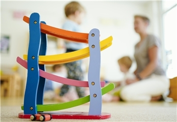 Eine Erzieherin spielt in einer Kita mit Kindern. (