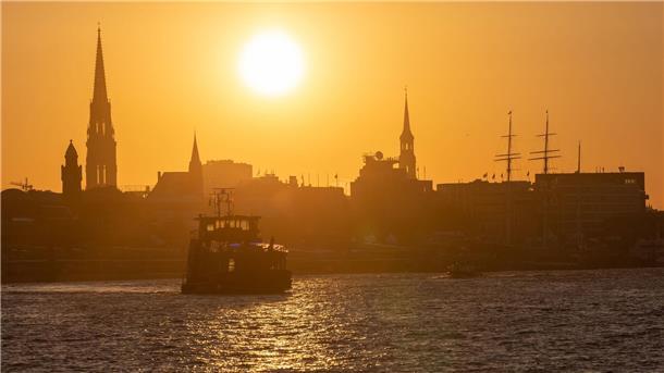 Umweltverbände fordern mehr Kooperation der Häfen Eine Fähre fährt am Morgen bei Sonnenaufgang im Hamburger Hafen.
