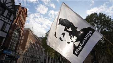 Eine Fahne mit dem Konterfei von Julian Assange wird bei einer Demonstration vor dem Royal Courts of Justice in London geschwenkt.