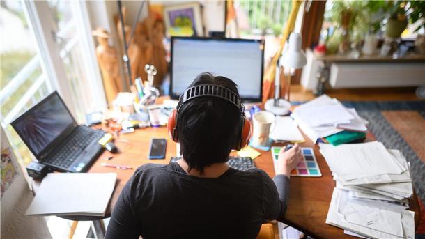 Eine Frau arbeitet mit Hörschutz im Homeoffice. Im Vergleich zur Vor-Corona-Zeit hat sich der Anteil der Menschen im Homeoffice nahezu verdoppelt.