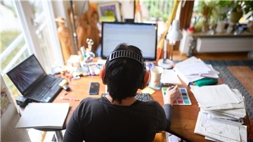 Eine Frau arbeitet mit Hörschutz im Homeoffice. Im Vergleich zur Vor-Corona-Zeit hat sich der Anteil der Menschen im Homeoffice nahezu verdoppelt.