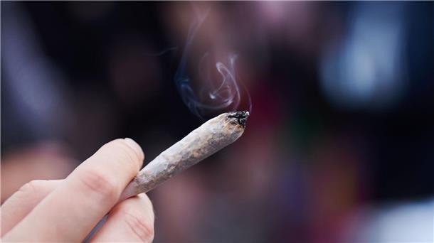 Koalition einig: Cannabis-Legalisierung zum 1. April Eine Frau hält einen Joint in der Hand: Cannabis wird von der Liste der verbotenen Substanzen gestrichen.