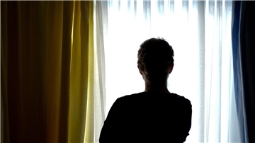 Eine Frau steht in einem Frauenhaus-Zimmer. 