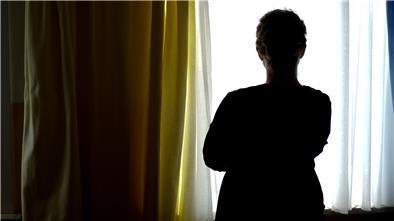 Eine Frau steht in einem Zimmer eines Frauenhauses. Betroffene von häuslicher Gewalt finden in solchen Einrichtungen Schutz. Für die Wesermarsch ist das Frauenhaus Ammerland-Wesermarsch die Anlaufstelle.