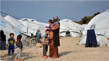 Eine Frau steht mit ihren Kindern im Flüchtlingslager Kara Tepe in der Nähe von Mytilini auf Lesbos.