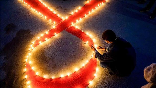 Welt-Aids-Konferenz: Millionen Infizierte ohne Therapie Eine Frau stellt Kerzen auf, die eine rote Schleife formen - ein weltweit anerkanntes Symbol für die Solidarität mit HIV-Infizierten.