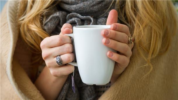 Kälteanpassung des Körpers - Wie Frostbeulen weniger frieren Eine Frau wärmt sich in Hannover, in eine Decke gehüllt, an einer Tasse Tee. Ab wann jemand friert, hängt von vielen Faktoren ab.