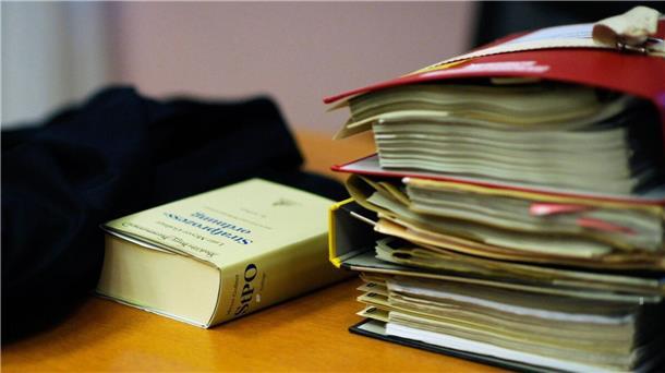 Akten und ein Gesetzbuch liegen auf dem Tisch eines Anwalts.