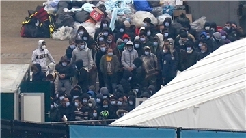 Eine Gruppe von Personen, bei denen es sich vermutlich um Migranten handelt, wartet auf ihre Registrierung in Dover.