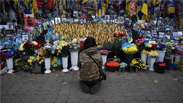 Bilder des Tages Eine junge Frau kniet am Unabhängigkeitsplatz Maidan in Kiew. Hier wird den Gefallenen des Krieges gedacht.