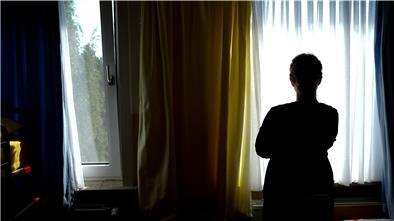 Eine junge Frau steht in einem Zimmer.