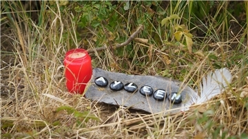 Eine Kerze und eine Tafel mit dem Namen Ayleen am Ufer des Teufelsee, wo die Leiche der 14-Jährigen  gefunden wurde.