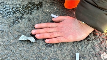 Eine Klimaaktivistin hat sich mit der Hand auf einer Hauptverkehrsstraße festgeklebt.