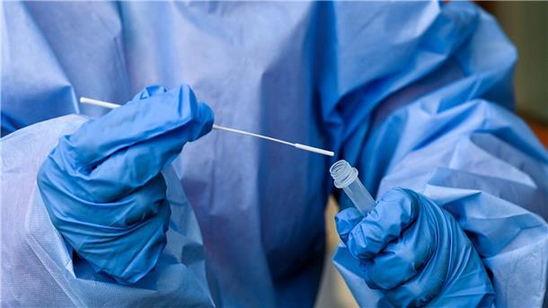 Corona-Infektionszahlen sinken weiter Eine Krankenschwester steckt ein Abstrichstäbchen in die Flüssigkeit eines Corona-Schnelltests.