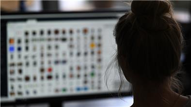Eine Kriminaloberkommissarin sitzt in einem Büro vor einem Auswertungscomputer auf der Suche nach Kinderpornografie und Fällen von sexuellem Missbrauch.