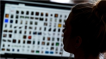 Eine Kriminaloberkommissarin sitzt vor einem Auswertungscomputer bei Ermittlungen zu Kinderpornografie und sexuellem Missbrauch.