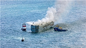 Eine Luftaufnahme zeigt einen deutschen Notschlepper(l), der das Feuer auf dem brennenden Frachter „Fremantle Highway“ bekämpft.