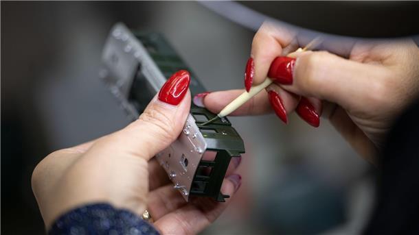 Eine Mitarbeiterin von Märklin führt Handmalarbeiten an einem lackierten Werkstück durch.