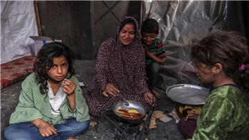 Eine palästinensische Familie kocht in einem behelfsmäßigen Zelt in Rafah.