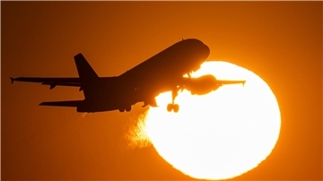 Eine Passagiermaschine hebt vor der untergehenden Sonne vom Flughafen Frankfurt ab.