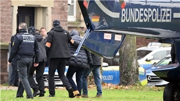 Razzia in „Reichsbürger“-Szene: Suche nach weiteren Spuren Eine Person (2.v.r.) wird von Polizisten aus einem Hubschrauber gebracht.