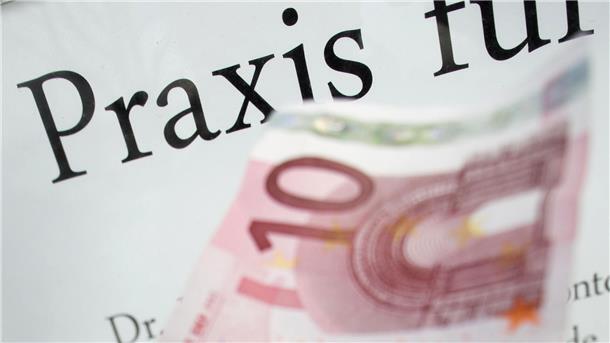 Ein Zehn-Euro-Schein wird vor das Schild einer Arztpraxis gehalten. 