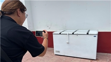 Eine Reporterin macht in einer Polizeistation in Pattaya ein Foto von der Kühltruhe, in der die Leiche von Hans-Peter M. gefunden wurde.