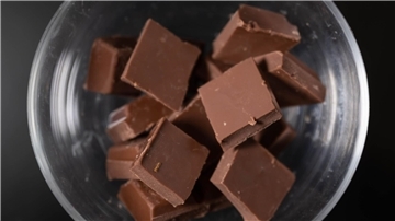 Eine Schale mit Schokolade steht auf einem Couchtisch. Der steigende Kakao-Preis könnte bald auch Auswirkungen auf die Schokolade im Supermarkt haben.