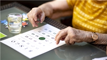 Eine Seniorin nimmt an einem Bingo-Turnier teil.