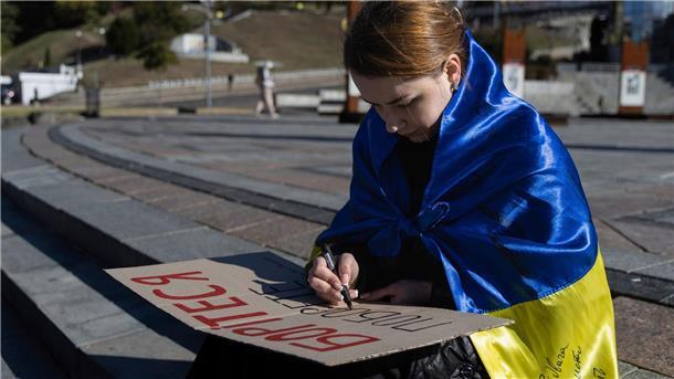 Krieg gegen die Ukraine: So ist die Lage Eine Studentin in Kiew schreibt die ersten Worte des ukrainischen Gedichts „Kämpfe weiter - du wirst siegen“ von Taras Schewtschenko auf ein Plakat.