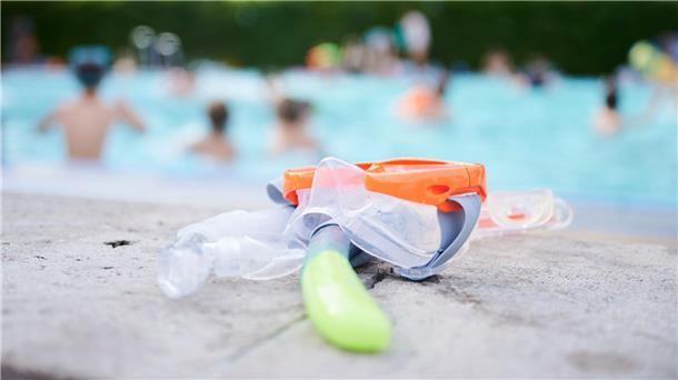 Straftaten in Schwimmbädern lange rückläufig Eine Taucherbrille und Schnorchel liegen in einem Schwimmbad am Beckenrand.