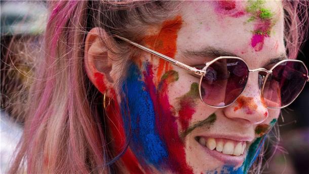 Farbe, Cannabis und schlagende Frauen: Indien feiert Holi Eine Touristin bedeckt ihr Gesicht mit farbigem Puder während der Holi-Feierlichkeiten in Nepal. Das Fest hat auch international viele junge Fans gefunden.