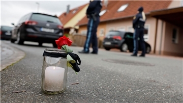 Eine Trauerkerze und eine Rose vor dem Haus, in dem eine 14-Jährige getötet wurde.