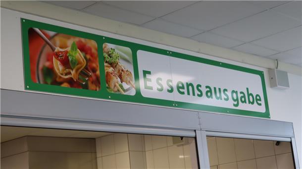 Ein Schild hängt über der Essensausgabe