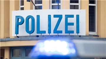 Ein Einsatzwagen der Polizei steht vor einer Dienststelle.