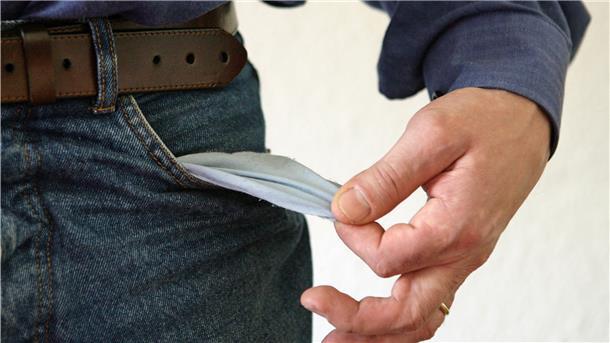 Ein Mann zieht kehrt die leere Innenseite seiner Jeans nach außen. 
