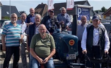 Das Foto zeigt ältere Männer vor und neben einem alten Traktor. Es handelt sich um ehemalige Schüler der Landwirtschaftsschule Stollhamm, die jetzt in Nordenham ein Wiedersehen gefeiert haben.