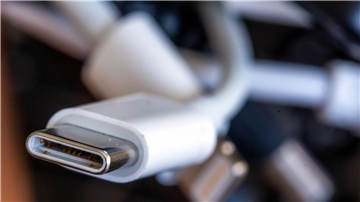  Ein Ladekabel mit USB-C-Stecker liegt neben einem Bündel unterschiedlicher Anschlusskabel. 