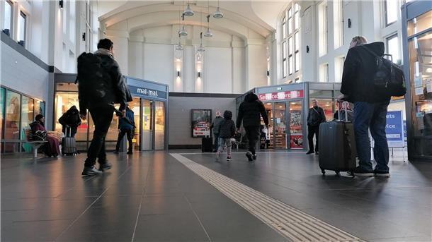 Reisende in der Bahnhofshalle.