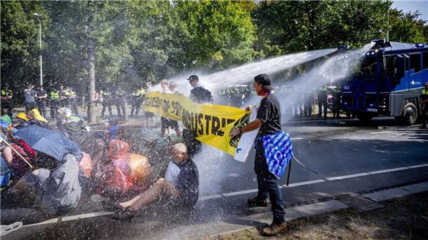 Fast 3000 Festnahmen bei verbotenen Klima-Demos in Den Haag Einsatz von Wasserwerfern gegen Klimaaktivisten, die eine Straße blockieren.