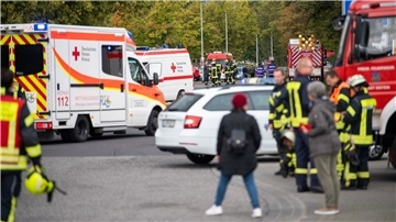 Einsatzkräfte der Feuerwehr und des Roten Kreuzes stehen nach einem Gasaustritt vor der Schule in Idstein