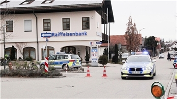 Einsatzkräfte der Polizei nach dem Überfall auf einen Geldtransporter in der Nähe einer Bank in Großkarolinenfeld in Bayern.
