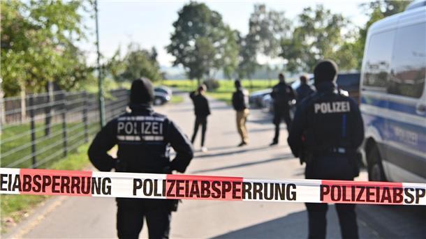 Faeser verbietet rechtsextremistische „Artgemeinschaft“ Einsatzkräfte der Polizei stehen hinter einer Polizeiabsperrung nach einer Razzia in Hesselbronn.