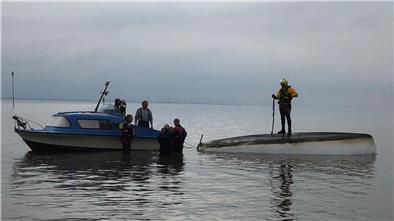 Einsatzkräfte orten das gekenterte Segelboot.