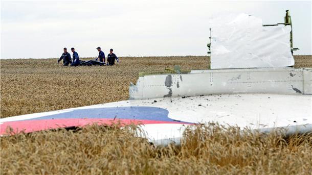 Ermittler: Putin hatte aktive Rolle bei MH17-Abschuss Einsatzkräfte transportieren eine Trage mit einem Leichensack durch ein Getreidefeld an der Absturzstelle der Boeing 777, die als Flug MH17 der Malaysia Airlines etwa 100 km östlich von Donezk abstürzte.