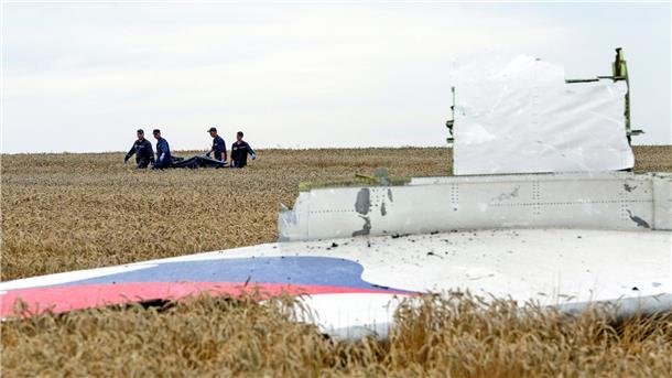 Abschuss von Flug MH17: Gericht spricht drei Männer schuldig Einsatzkräfte transportieren im Juli 2014 eine Trage mit einem Leichensack durch ein Getreidefeld an der Absturzstelle der Boeing 777 der Malaysia Airlines.