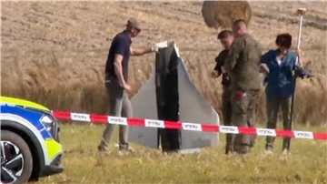 Einsatzkräfte von Polizei und Militärpolizei sichern Teile einer beschädigten Drohne.