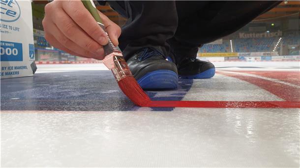 Eismeister Julian Gardeln malt auf der Spielfläche der Eisarena Bremerhaven die Linien am Bullypunkt.