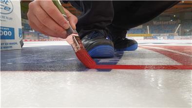 Eismeister Julian Gardeln malt auf der Spielfläche der Eisarena Bremerhaven die Linien am Bullypunkt.