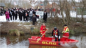 Eiswettschneider Christian Schwertfeger prüft die Aue vom DLRG-Boot aus mit einem glühenden Bügeleisen und stellt fest: „De Aue geiht". 